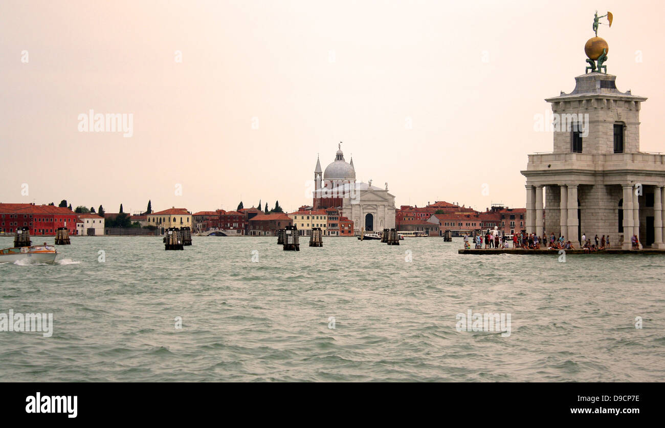 Dreieckigen Punta della Dogana, (das ehemalige Zollhaus der Stadt) trennt den Grand Canal und der Canale della Giudecca in Venedig, Italien. Heute ist es ein Zentrum für zeitgenössische Kunst im 17. Jahrhundert. Der Turm halten sie eine goldene Kugel, das von zwei Atlanten unterstützt wird; diese Statue stellt Vermögen. Es wurde von Bernardo Falconi geformt Stockfoto