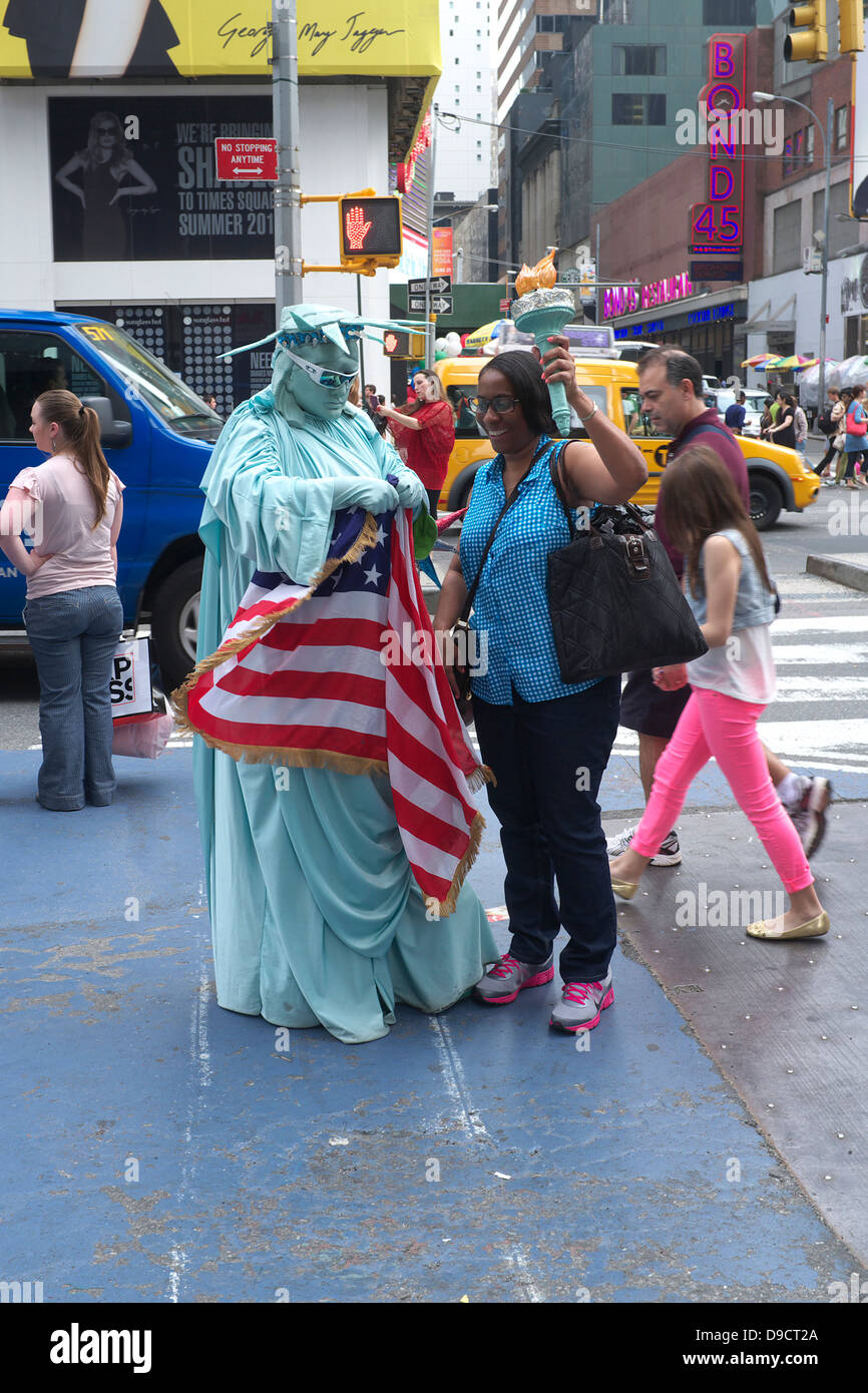 Afroamerikanische Frau mit Fackel Mann verkleidet als Statue of Liberty Times Square, New York City Stockfoto