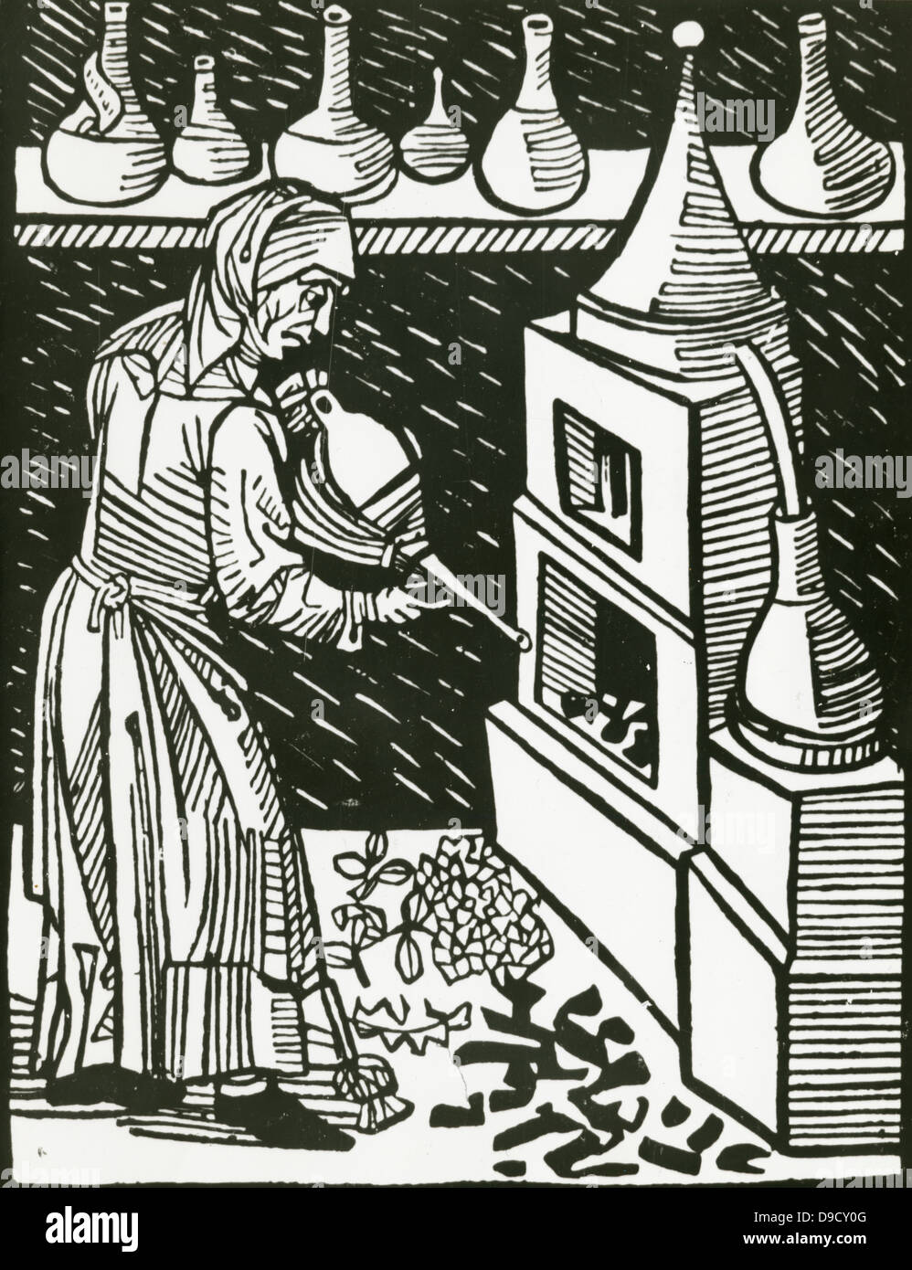 Weiblichen Operator anwenden Balg auf den Ofen während der Destillation.  Holzschnitt, 1514. Stockfoto