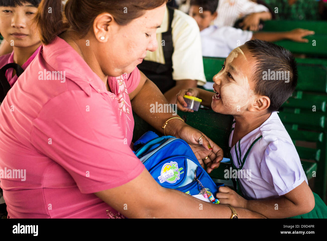 17. Juni 2013 - Yangon, Myanmar - eine Frau nimmt ihre Tochter nach Hause auf der Fähre von Yangon-Dala nach der Schule. Die Fähre nach Dala gegenüberliegenden Yangon auf dem Yangon-Fluß ist die wichtigste Form der Transport über den Fluss. Jeden Tag fährt die Fähre Zehntausende von Menschen über den Fluss. Viele Arbeiterklasse Burmesen in Dala lebe und arbeite in Yangon. Die Fähre ist auch beliebt bei Touristen, die die "echte" Myanmar erleben wollen. Die Fahrt dauert etwa 15 Minuten. Birmanisch zahlen ungefähr das Äquivalent von. 06¢ US für ein Ticket. Ausländer zahlen ungefähr das Äquivalent von ungefähr 4,50 US $ für das gleiche Ticket. (Credit Stockfoto