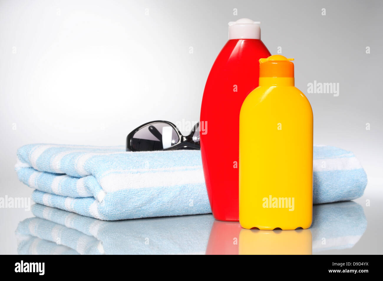 Solar Milch, Lotion, Handtuch und Sonnenbrillen Stockfoto