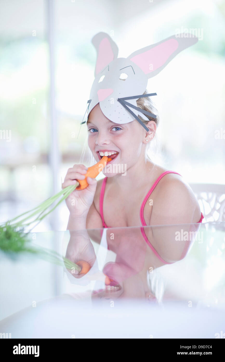 Mädchen in Tracht der Kaninchen Essen Karotte Stockfoto