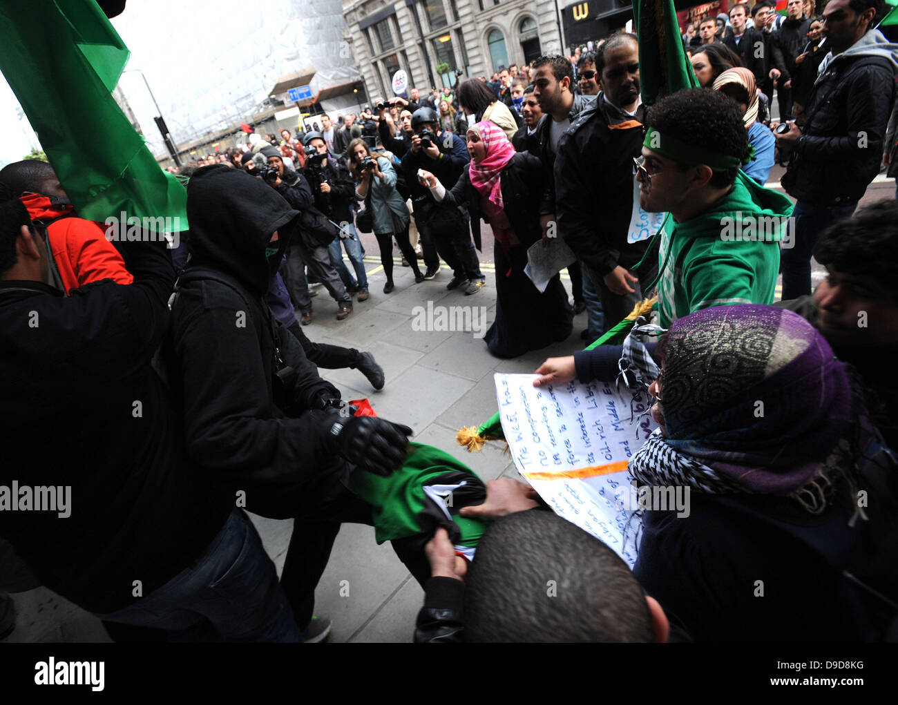 Libysche pro-Gaddafi-Anhänger attackieren gewaltsam eine Gruppe von Demonstranten, die die Flagge der libyschen Rebellen während des Marsches für die Alternative - TUC Demonstration im Zentrum von London. London, England - 26.03.11 Stockfoto