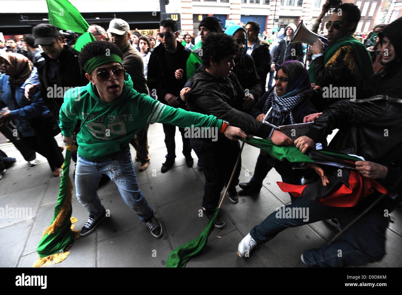 Libysche pro-Gaddafi-Anhänger attackieren gewaltsam eine Gruppe von Demonstranten, die die Flagge der libyschen Rebellen während des Marsches für die Alternative - TUC Demonstration im Zentrum von London. London, England - 26.03.11 Stockfoto