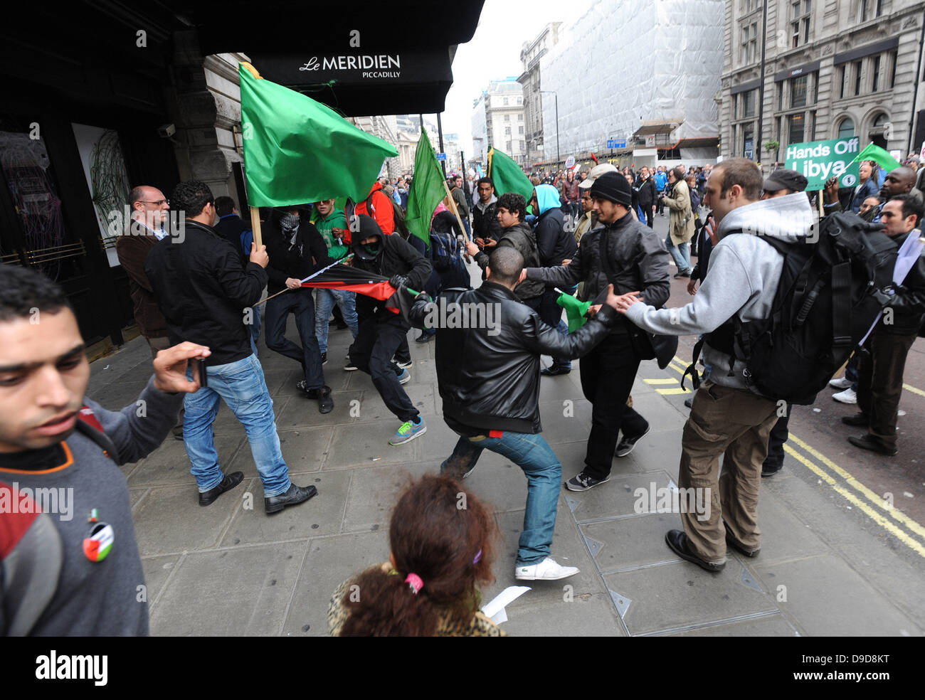 Libysche pro-Gaddafi-Anhänger attackieren gewaltsam eine Gruppe von Demonstranten, die die Flagge der libyschen Rebellen während des Marsches für die Alternative - TUC Demonstration im Zentrum von London. London, England - 26.03.11 Stockfoto