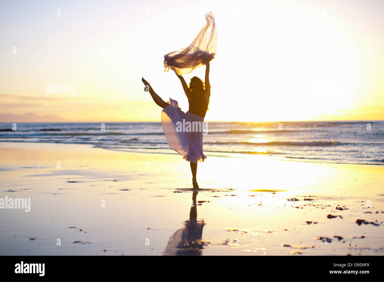 Junge Frau am sonnigen Strand tanzen Stockfoto