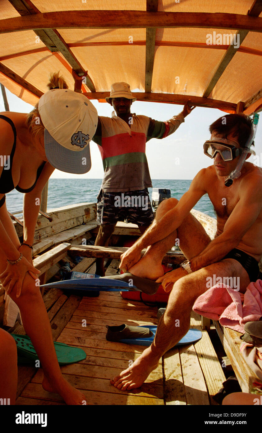 Agnes Duart (left) Xavier Larramendy setzen auf Schnorcheln Ausrüstung Riff vor Zanzibar, während Kapitän Solomon Kassim auf Larramendy sieht Stockfoto