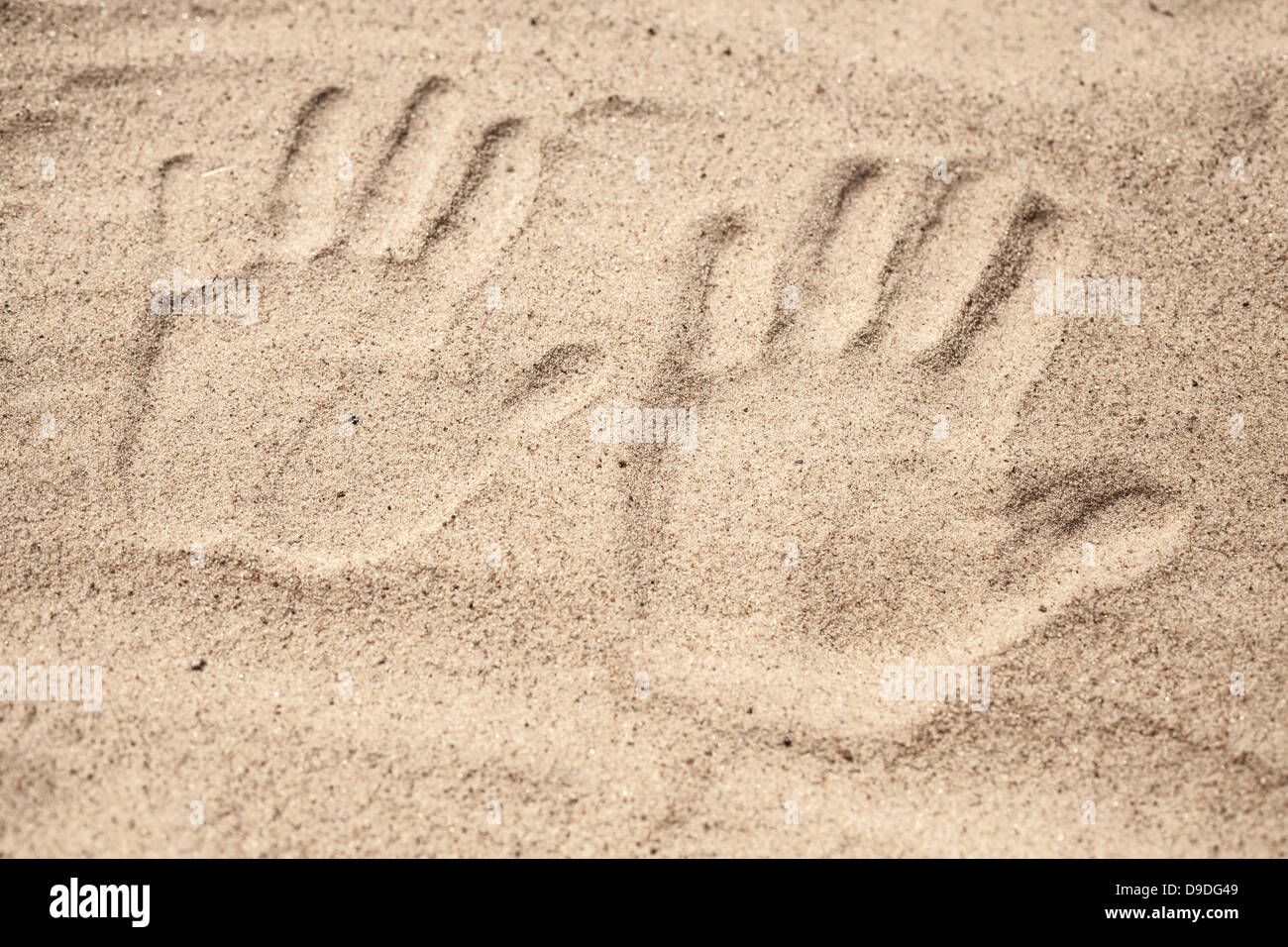 Zwei Handabdrücke in den Strandsand Stockfoto