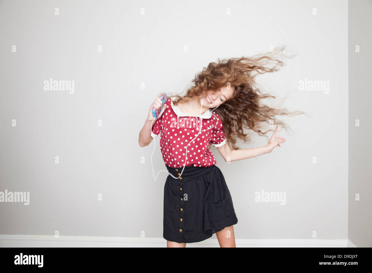 Mädchen mit Kopfhörern, tanzen und halten MP3-player Stockfoto