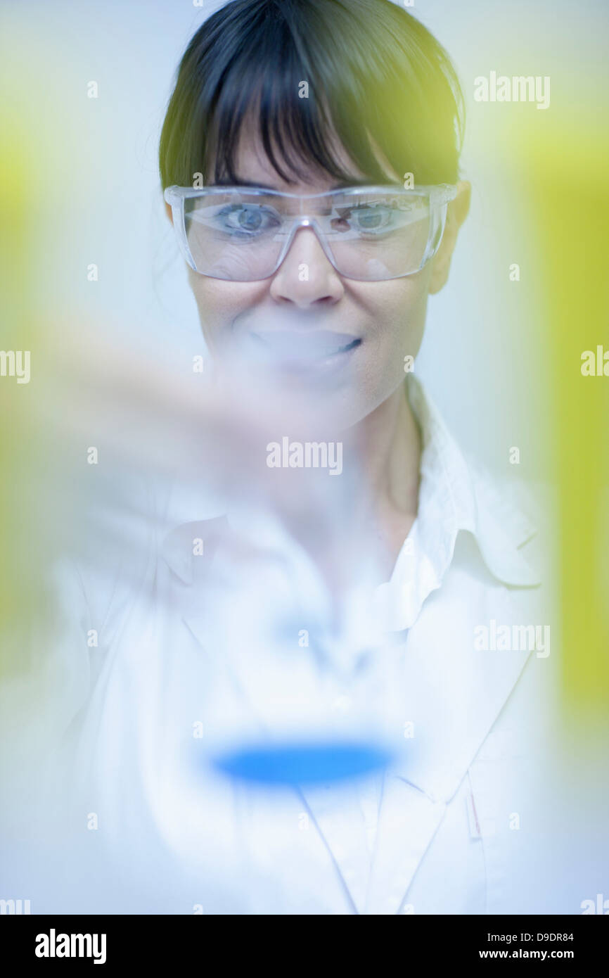 Frau hält Labor Becher Stockfoto