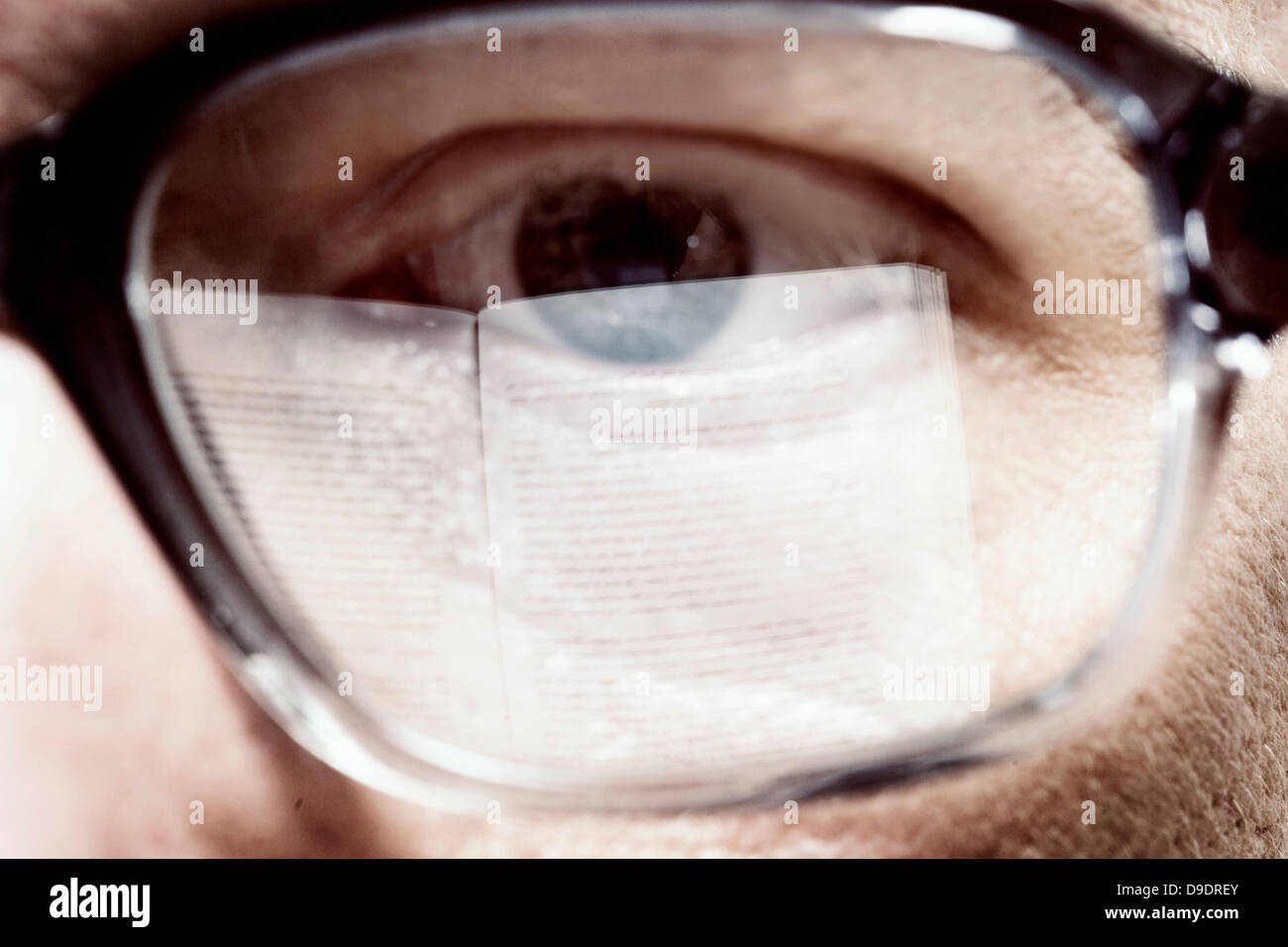 Nahaufnahme eines Mannes Auge Buch mit Brille Stockfoto