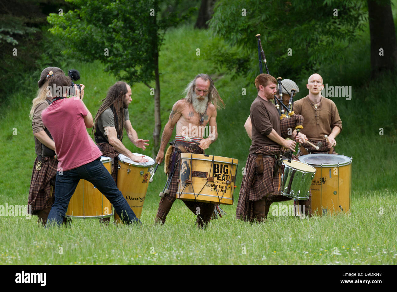 Kelvingrove Park, Glasgow, Schottland, UK, 18. Juni 2013. Torf-Trommeln und Dudelsäcken traditionellen schottischen Bigband spielen Musik für die Einheimischen während der Aufnahme eines neuen Videos. Großen Torf kann in der Regel in Buchanan Street in Glasgow zu sehen und sind durchaus eine berühmte Gruppe. Paul Stewart/Alamy Live-Nachrichten Stockfoto