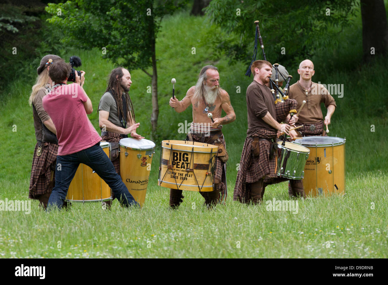 Kelvingrove Park, Glasgow, Schottland, UK, 18. Juni 2013. Torf-Trommeln und Dudelsäcken traditionellen schottischen Bigband spielen Musik für die Einheimischen während der Aufnahme eines neuen Videos. Großen Torf kann in der Regel in Buchanan Street in Glasgow zu sehen und sind durchaus eine berühmte Gruppe. Paul Stewart/Alamy Live-Nachrichten Stockfoto