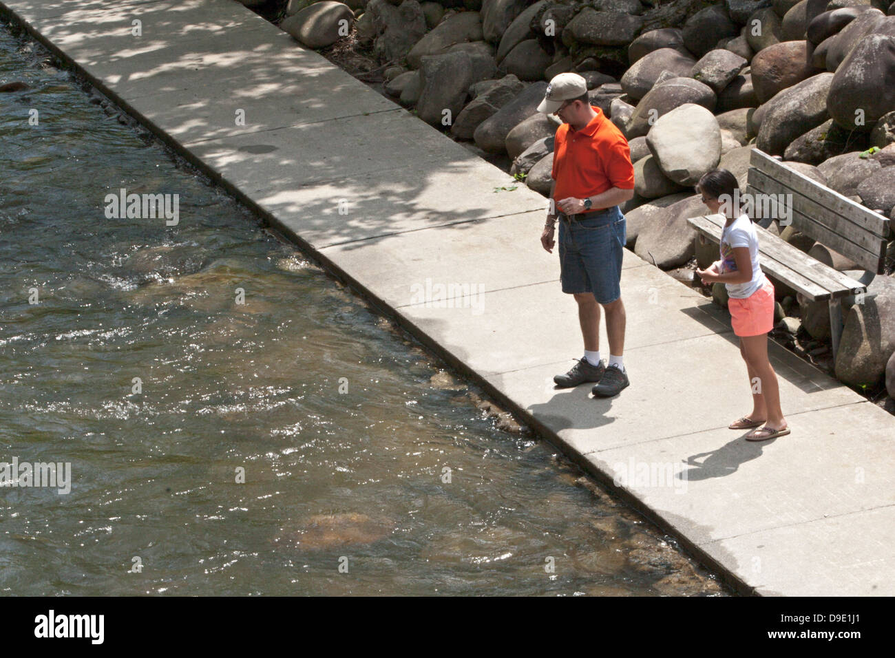 Mann und Mädchen suchen in Stream vom Bürgersteig Stockfoto
