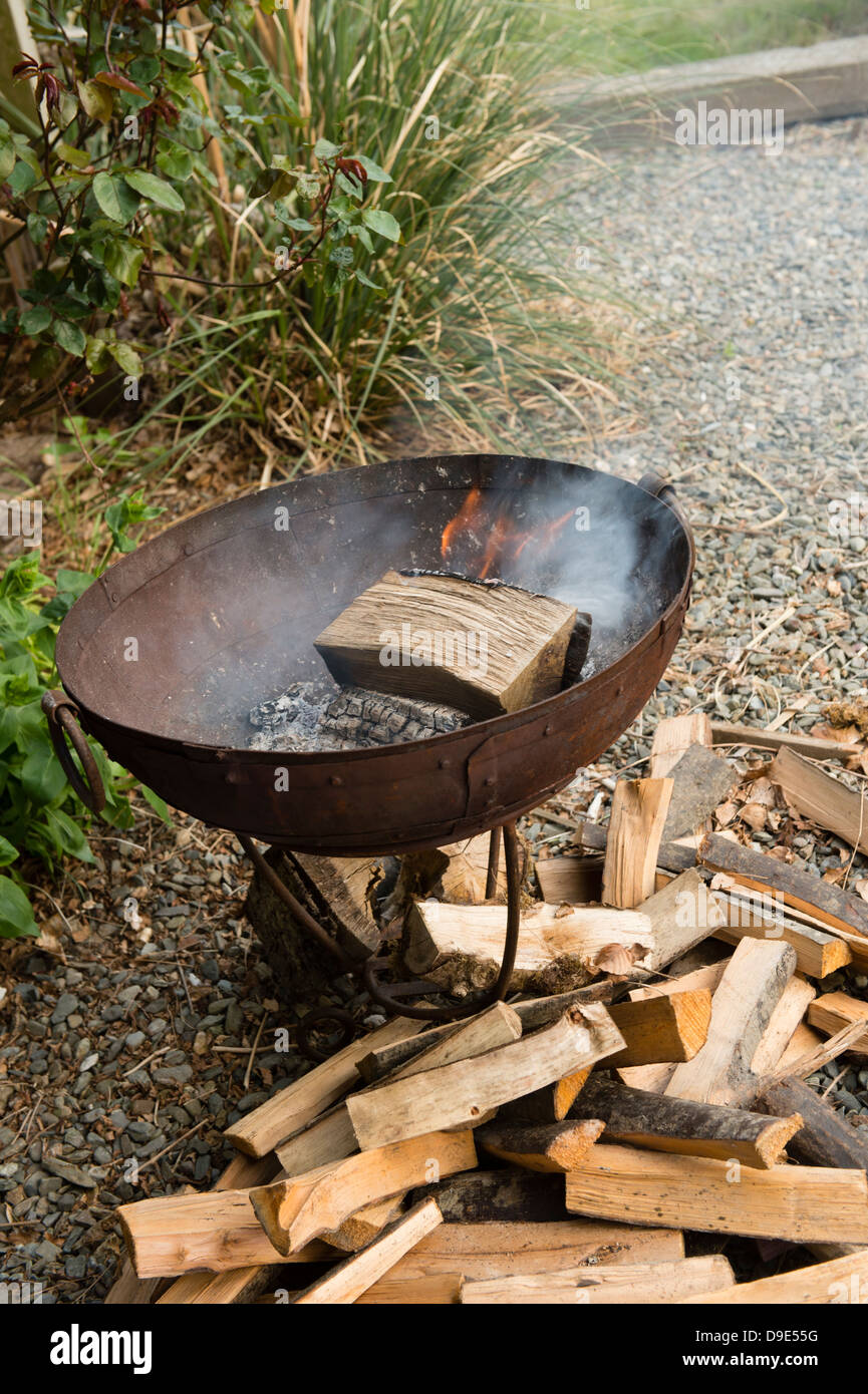 Ein Protokoll auf einem Lagerfeuer Metall Firepit brennen Stockfoto