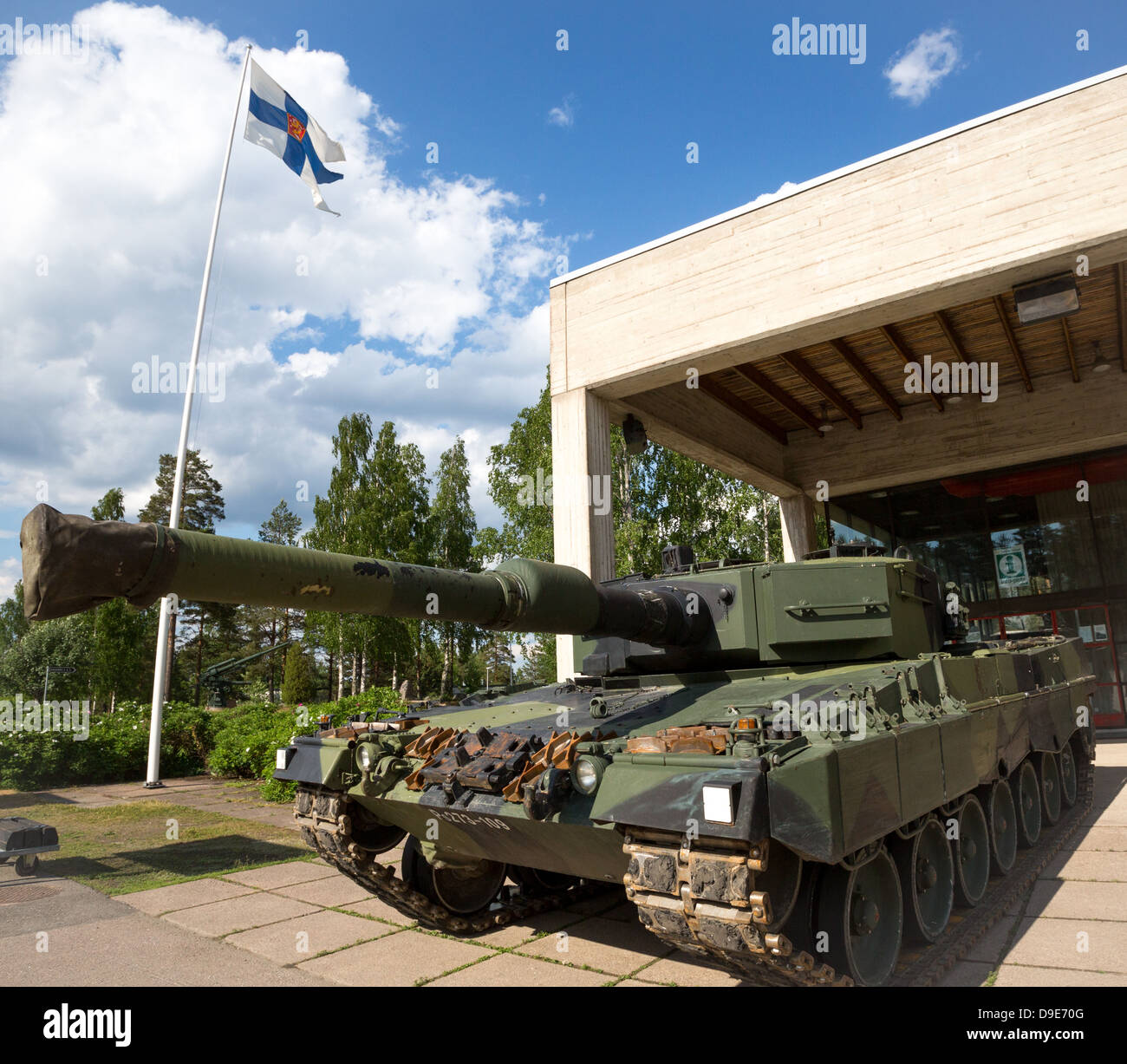 "Augenzwinkernd" Weitwinkel-Bild ein Kampfpanzer Leopard 2 A4 vor der finnischen Flagge der Streitkräfte. Stockfoto