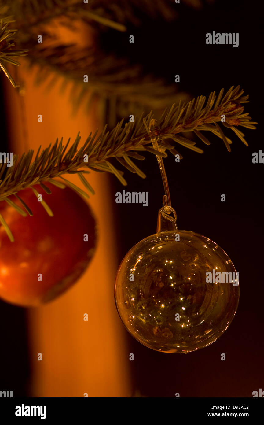 Einen traditionellen Weihnachtsbaum mit einer Klarglas-Christbaumkugel und Apfel im Hintergrund Stockfoto