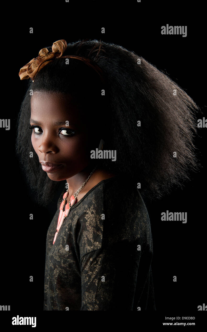 Junge afrikanische Frau mit schönen Afro-Haar, ein niedriger wichtige Hintergrund-Studio gedreht. Dramatische Gesichtsausdruck. Weiche schöne Haut. Stockfoto
