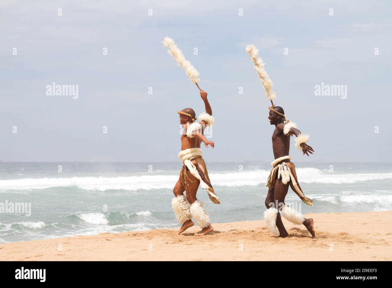 zwei afrikanische Zulu-Männer tanzen am Strand Stockfoto