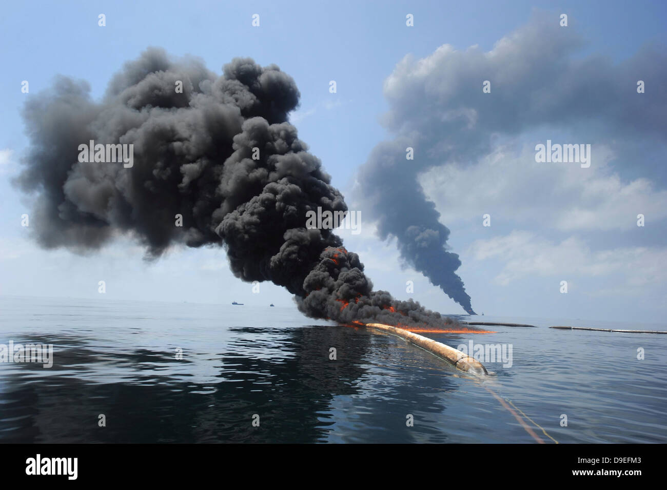 Dunkle Wolken von Rauch und Feuer entstehen, wie bei einem kontrollierten Brand in den Golf von Mexiko Öl verbrennt. Stockfoto
