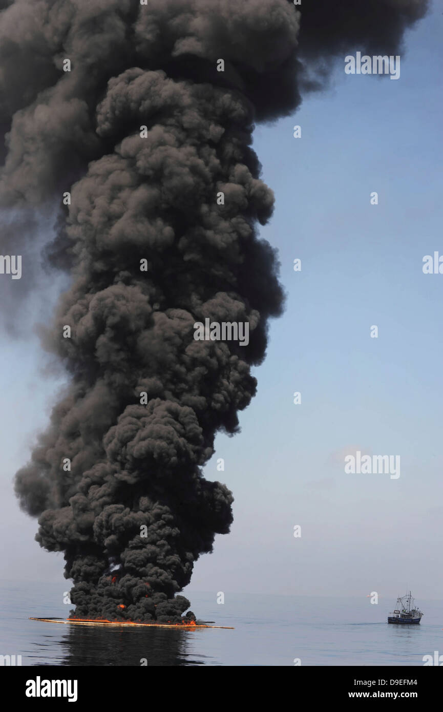 Dunkle Wolken von Rauch und Feuer entstehen, wie bei einem kontrollierten Brand in den Golf von Mexiko Öl verbrennt. Stockfoto