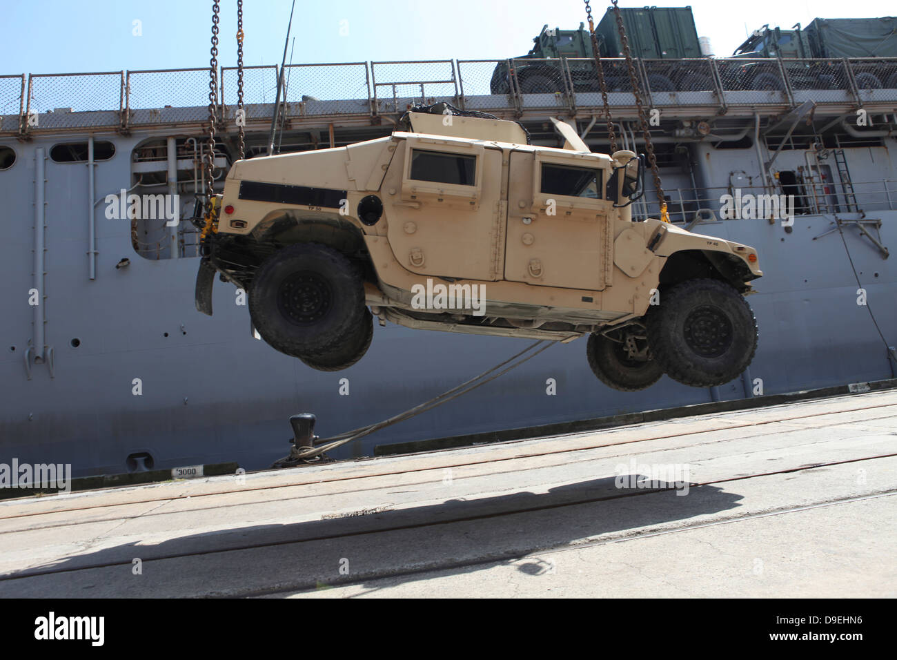Ein Kran hebt ein Humvee M998 auf dem Flugdeck der USS Carter Hall. Stockfoto