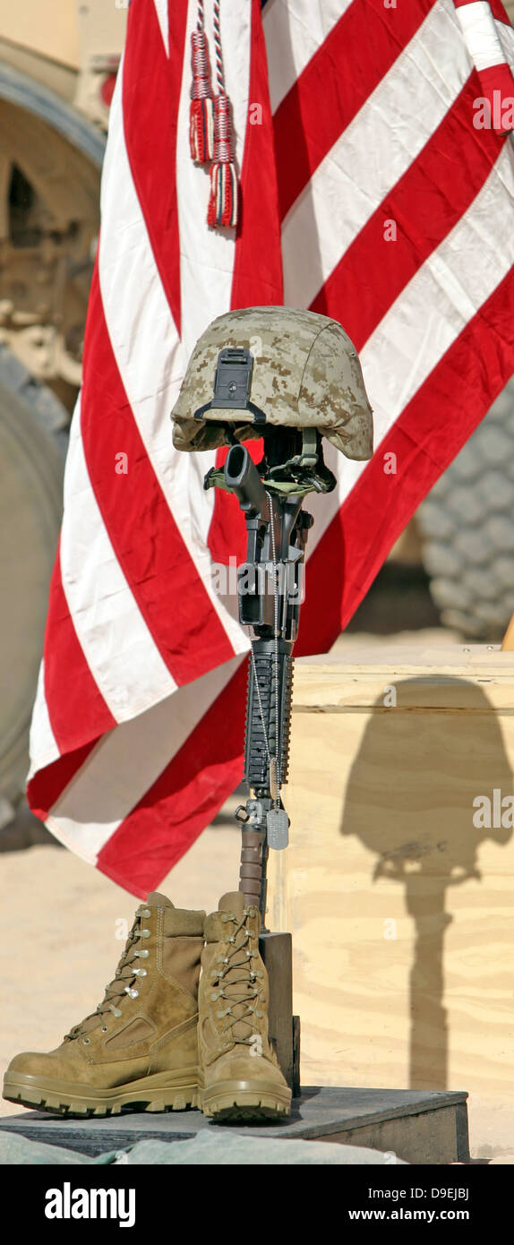 Ein Schlachtfeld Gedenkkreuz Gewehr Display steht stramm, während einer Trauerfeier. Stockfoto