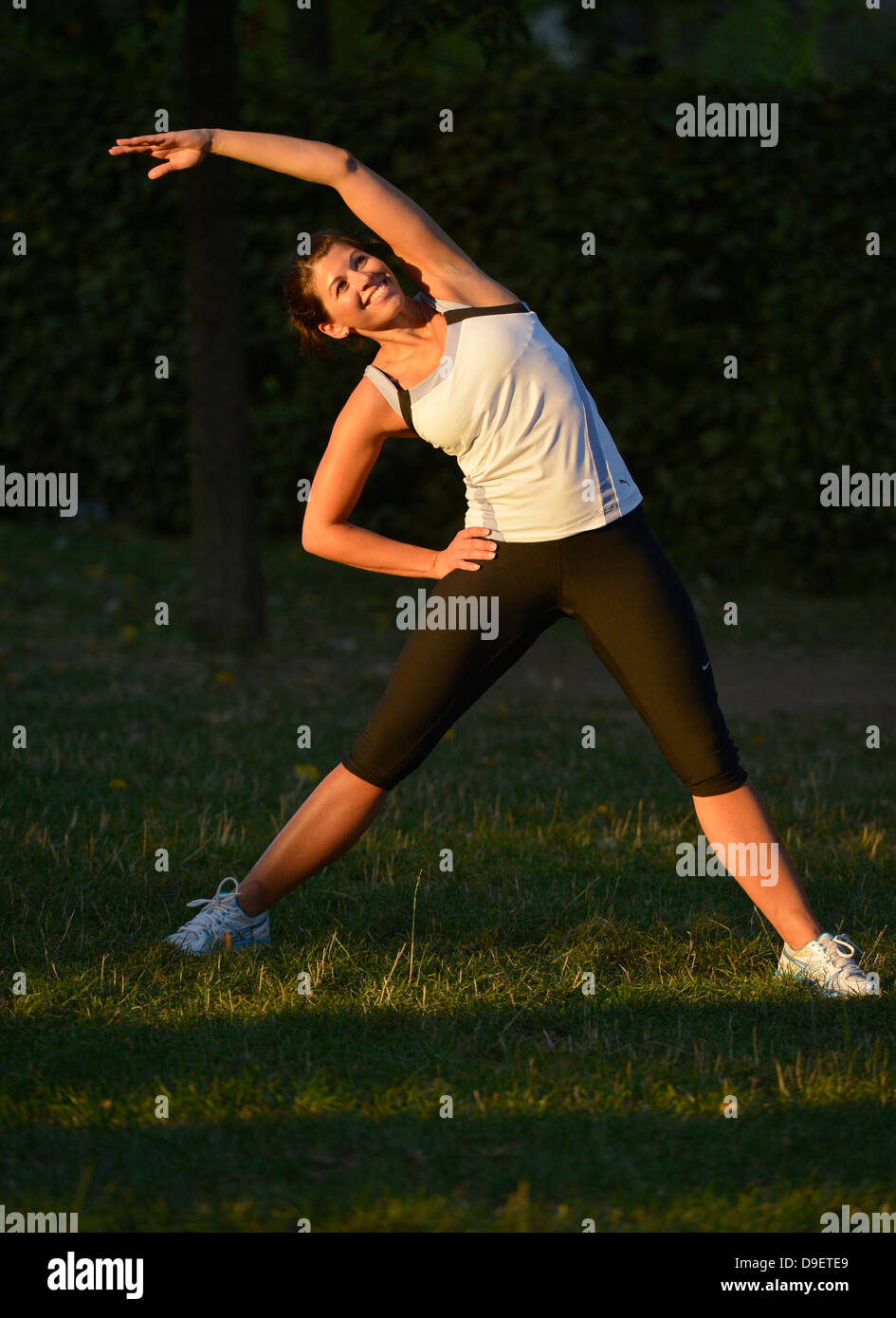 (Model Release) Junge Frau beim Aufwärmen, dehnen, stretching, Yoga, Joggen Stockfoto