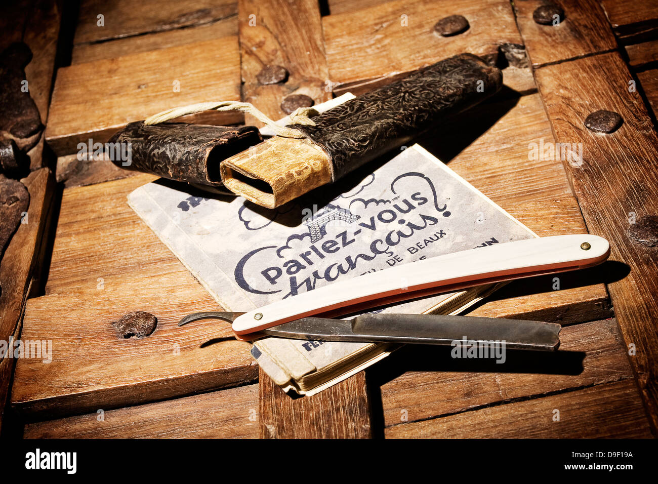 Rasierer mit Wörterbuch auf einer Holzkiste Rasiermesser mit einem Wörterbuch auf einem KUGELPUNZEN aus Holz Stockfoto