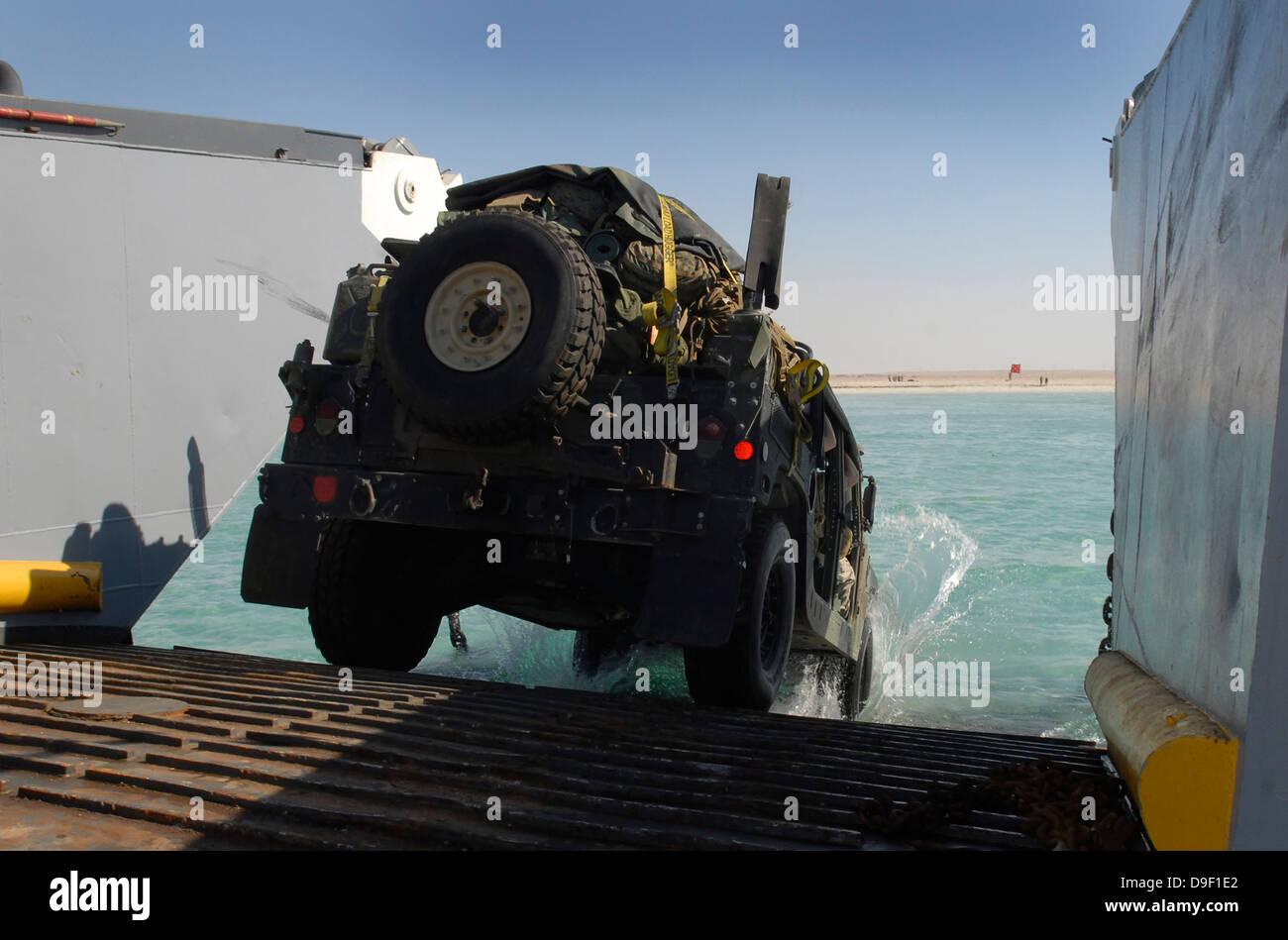 Ein Humvee fährt über die Rampe ein Landungsboot-Dienstprogramm. Stockfoto