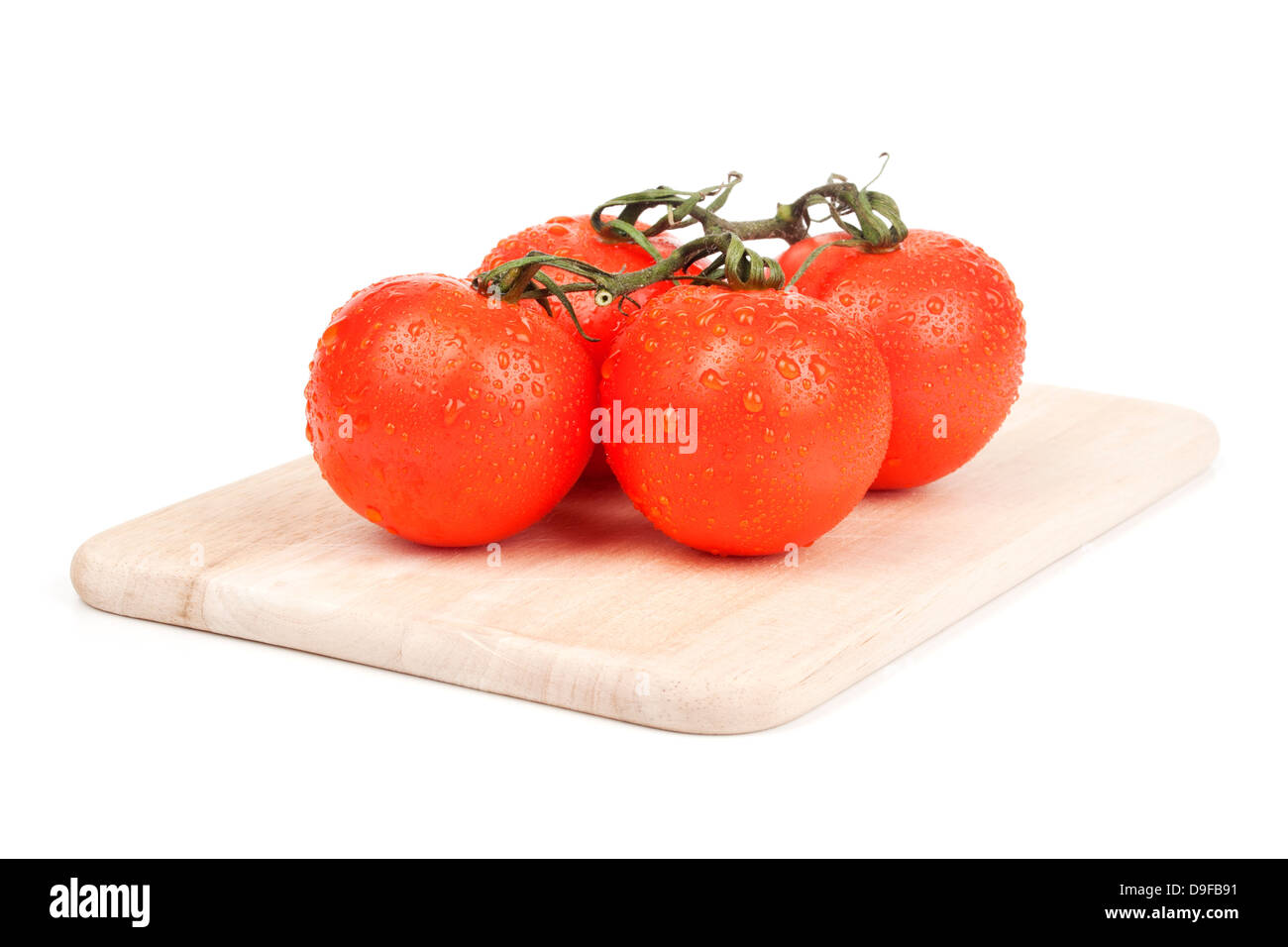 Strauch-Tomaten auf einem Holzbrett Tomaten auf einem Holzbrett Stockfoto