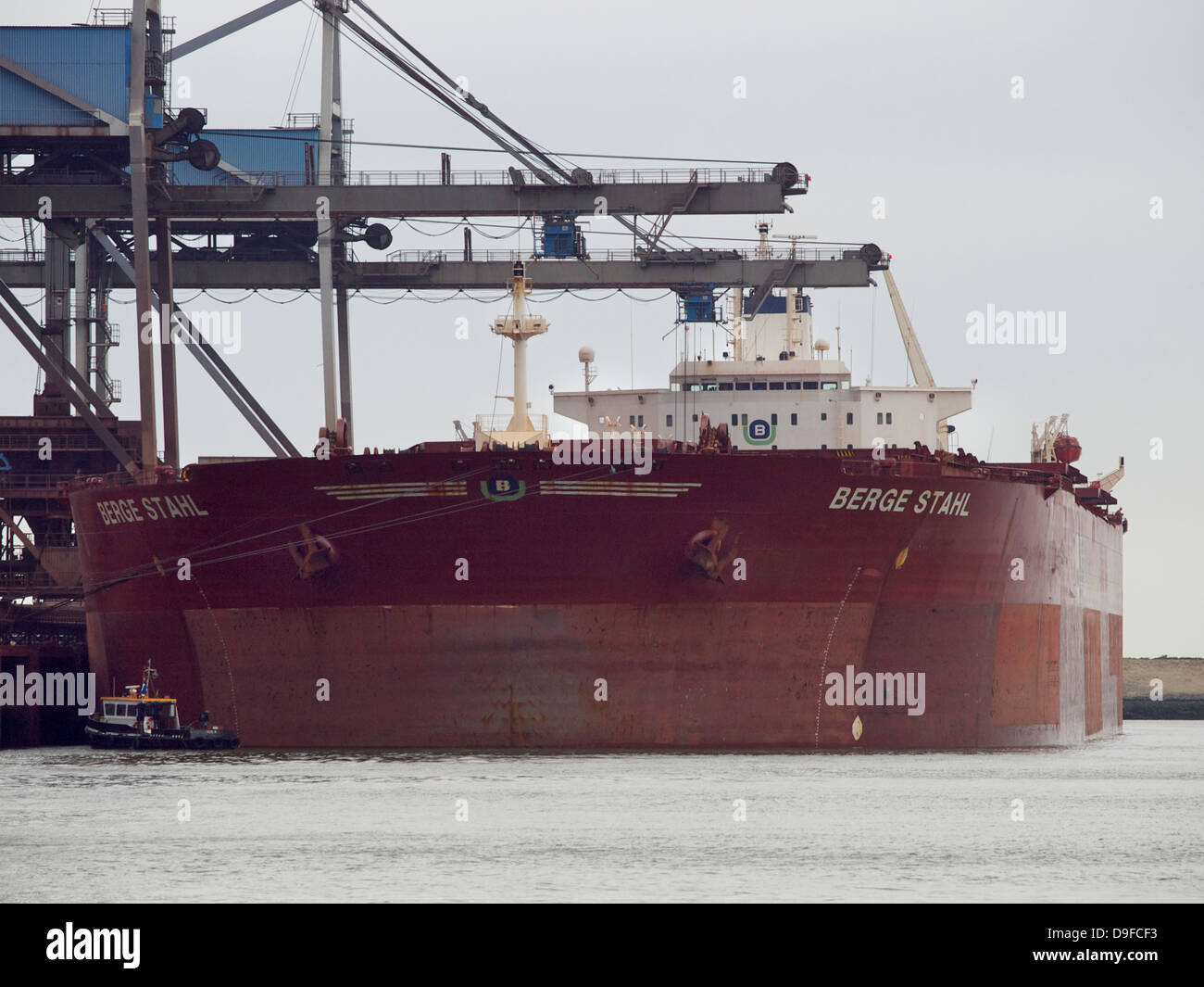 Kleines Boot in der Nähe der Berge Stahl einer der größten Massengutfrachter der Welt. Hafen von Rotterdam, die Niederlande Stockfoto