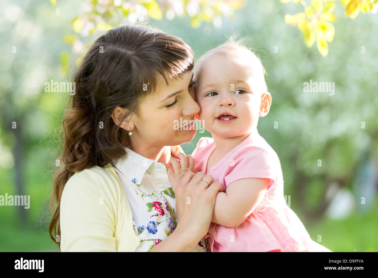 süße Mutter mit Babymädchen im freien Stockfoto