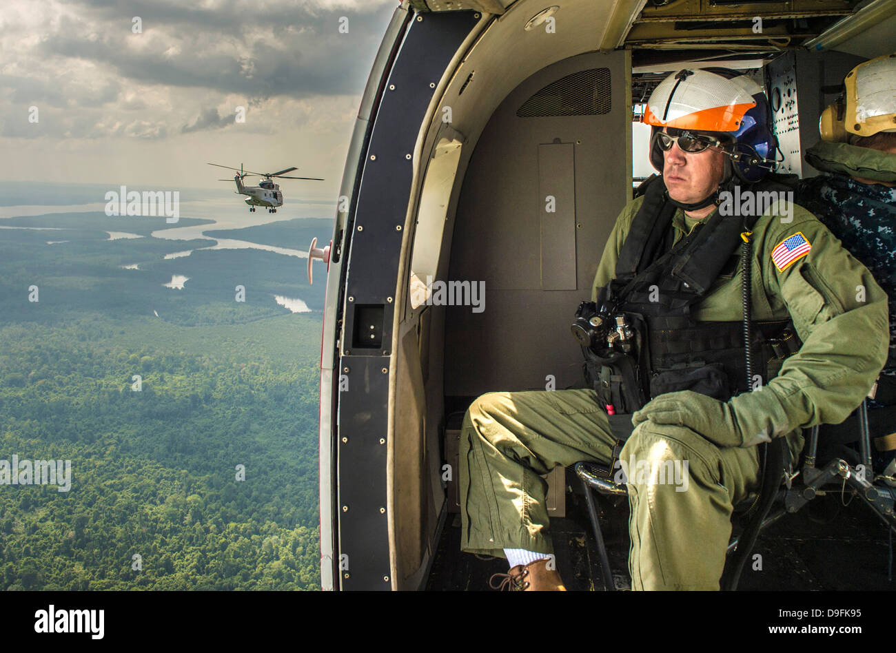 Ein US-Marine Seemann fliegt über den Dschungel an Bord eines SA330J Puma-Hubschraubers befestigt, die USNS Matthew Perry bei multilateralen Übungen 17. Juni 2013 in Brunei. Stockfoto