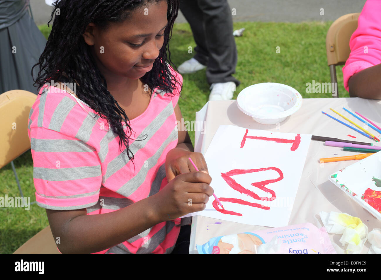 Ein junges Mädchen malen ein Zeichen, das liest, ich liebe dich. Stockfoto
