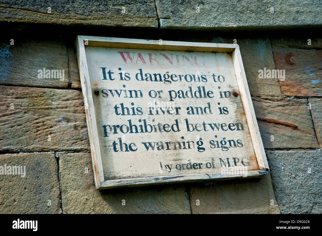 Warnschild "Gefahr", das an einer Wand angebracht ist, um im Fluss zu schwimmen oder zu paddeln England Großbritannien GB Großbritannien Stockfoto