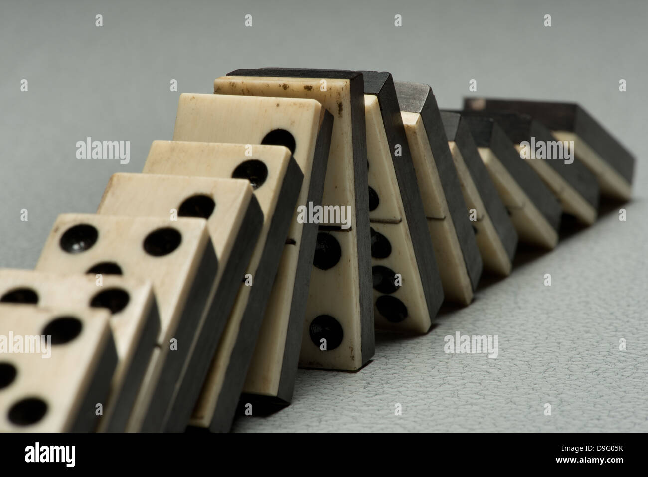 Reihen von aufgereiht altes Elfenbein und Ebenholz Bronze angehefteten stehende Domino blockiert Stücke auf weißem Tan Travertin-Marmor Stockfoto