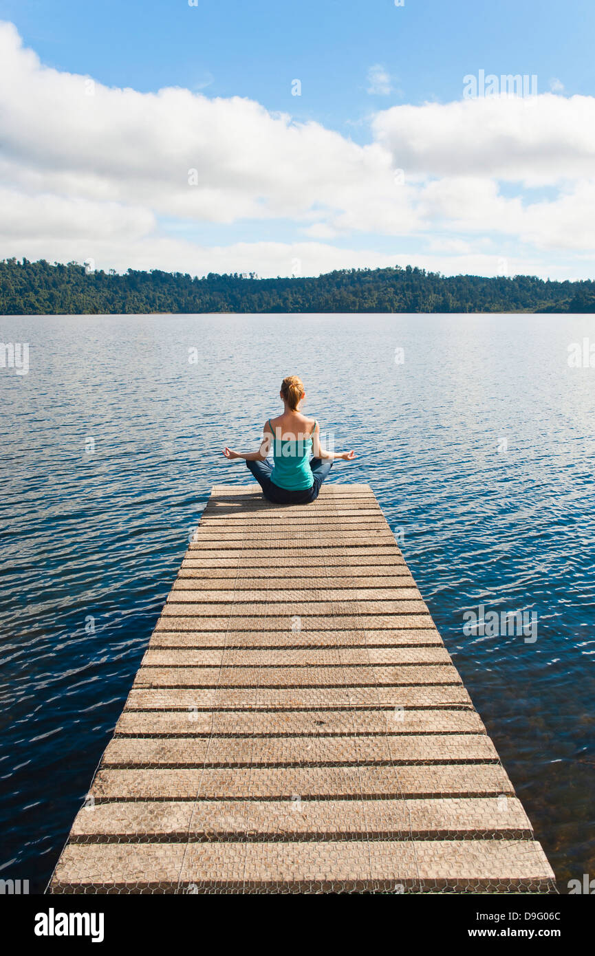 Frau, meditieren auf einem Steg, See zeichnet, West Coast, Südinsel, Neuseeland Stockfoto