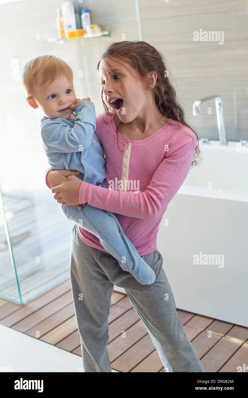 Mädchen tragen ihren Bruder und suchen in einem Badezimmer ... Mädchen tragen ihren Bruder und suchen in einem Badezimmer ...