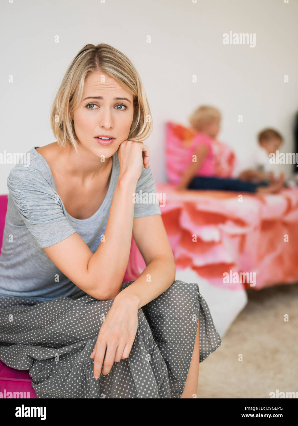 Frau, die mit ihren Kindern im Hintergrund sorgen Stockfoto