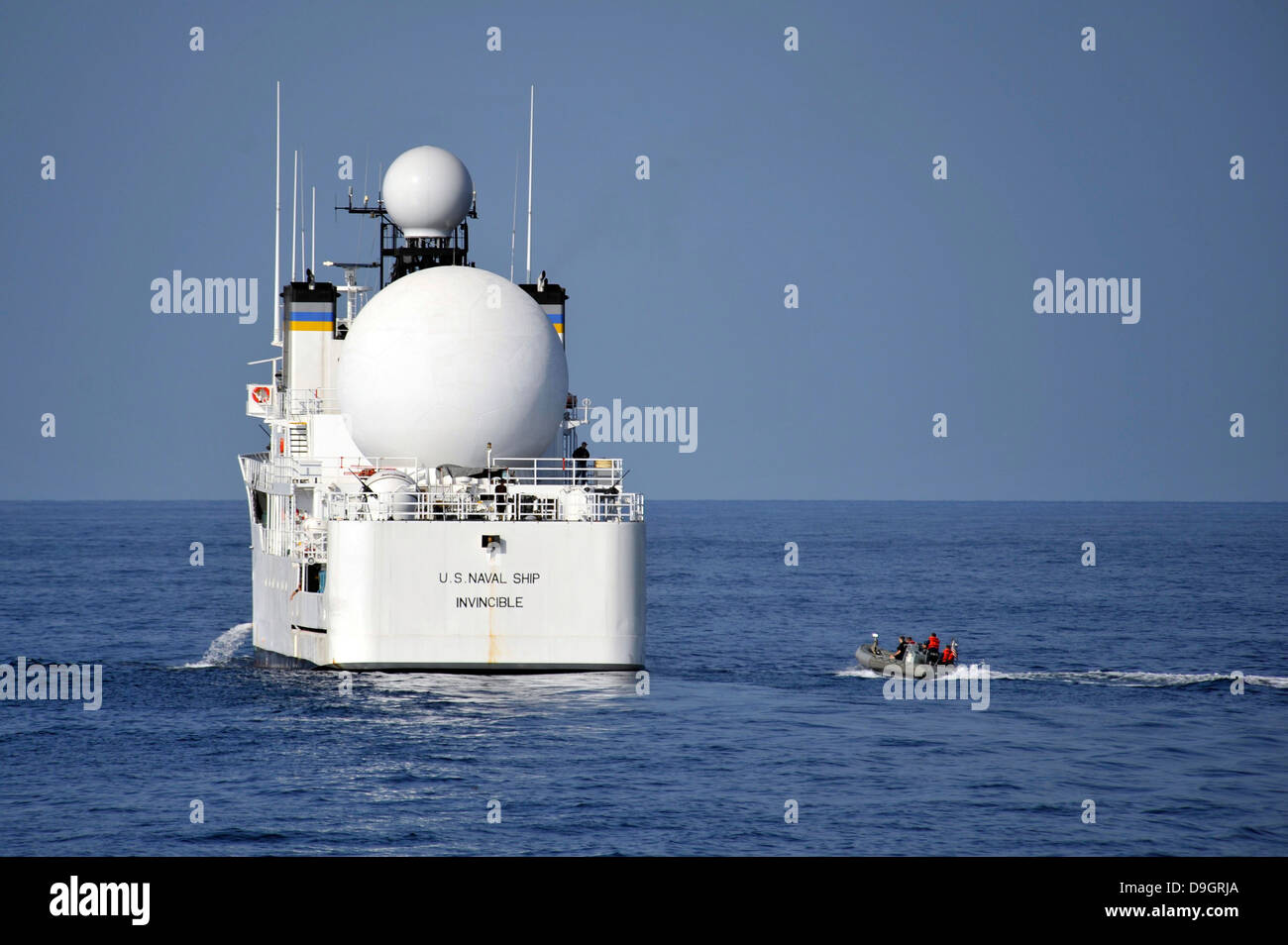 Segler in einem Festrumpf Schlauchboot nähern USNS unbesiegbar. Stockfoto