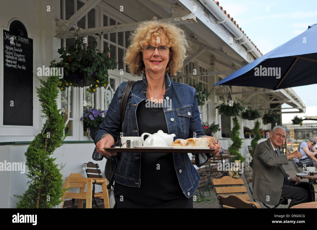 Frau mit einem Tablett an Getränken in einem Gartencenter Wyevale café Stockfoto