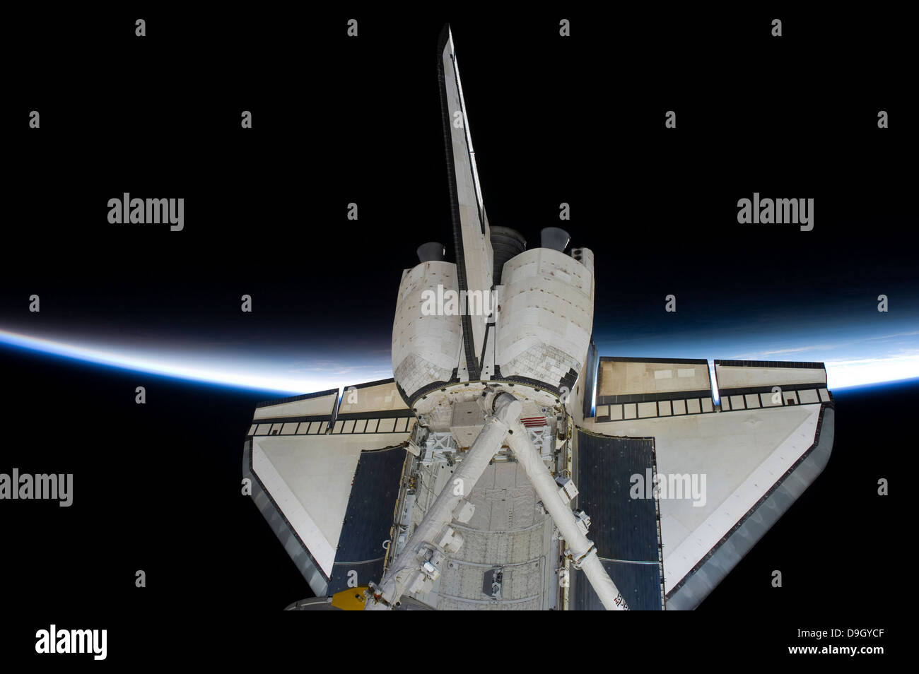 Space Shuttle Discovery schneidet die dünne Linie der Erdatmosphäre, während mit der internationalen Raumstation ISS angedockt. Stockfoto