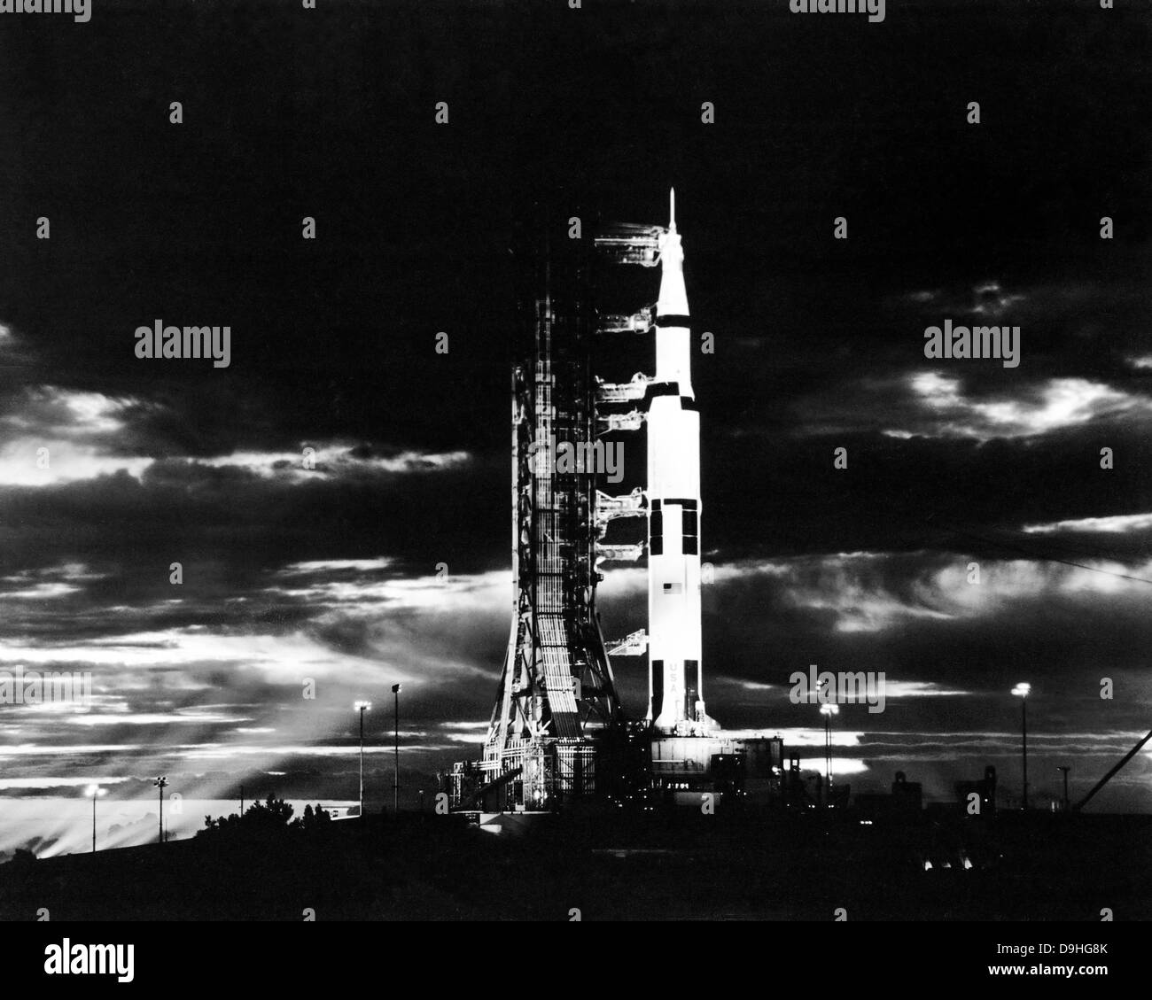 Suchscheinwerfer beleuchten diese Nachtansicht von Apollo 17 Raumfahrzeugen auf seine Launchpad. Stockfoto
