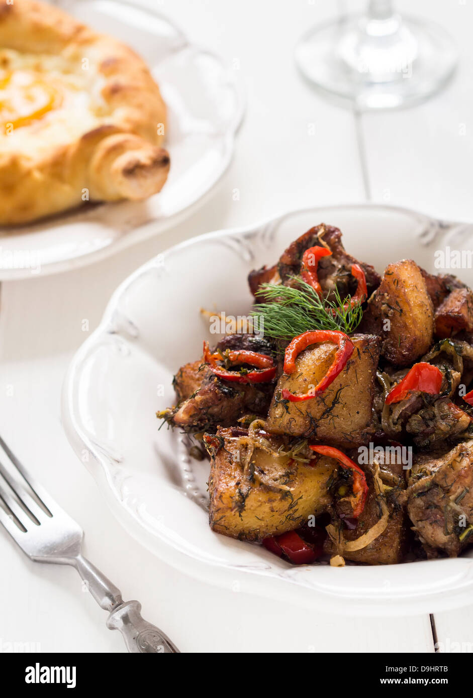 Georgische Küche: Ojakhuri - Schweinefleisch mit Kartoffeln und Gewürzen auf einem weißen Teller. Stockfoto