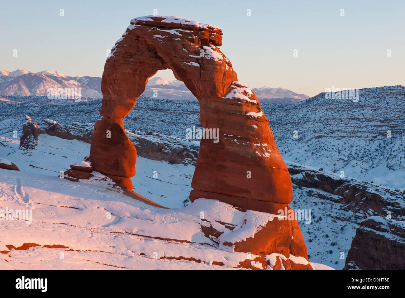 Delicate Arch mit Schnee im Winter bei Sonnenuntergang, Arches-Nationalpark, Utah, Vereinigte Staaten von Amerika Stockfoto