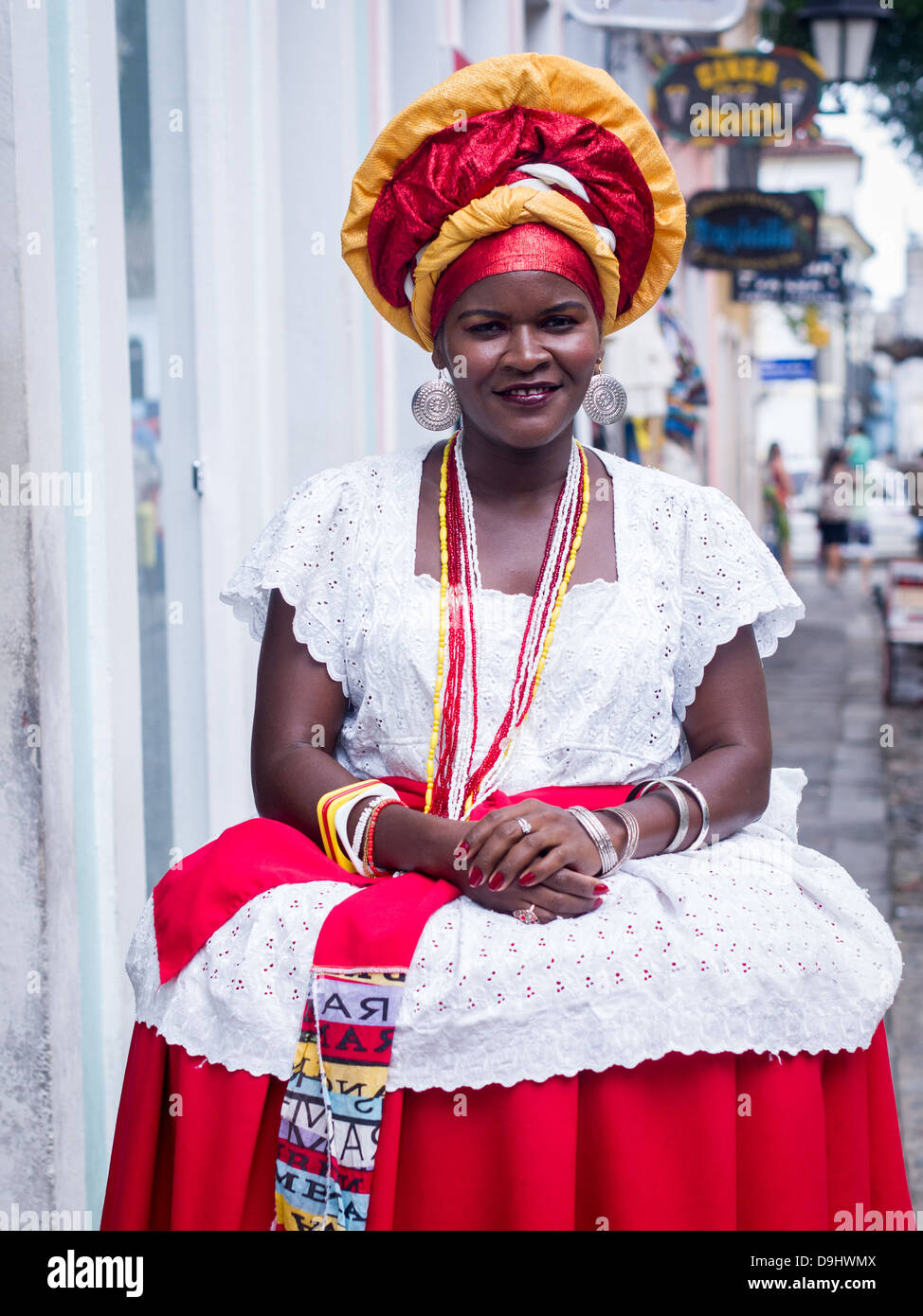 Frau trägt traditionelle Kleidung aus der Region Bahia Brasilien fördert Touristen o kaufen Souvenirs in Salvador. Stockfoto