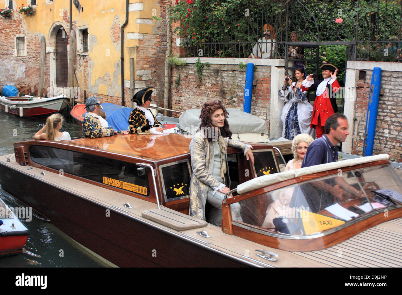 Karneval in Venedig, Italien.  Menschen in Tracht zu einer Karnevalsparty mit dem Wassertaxi ankommen. Stockfoto