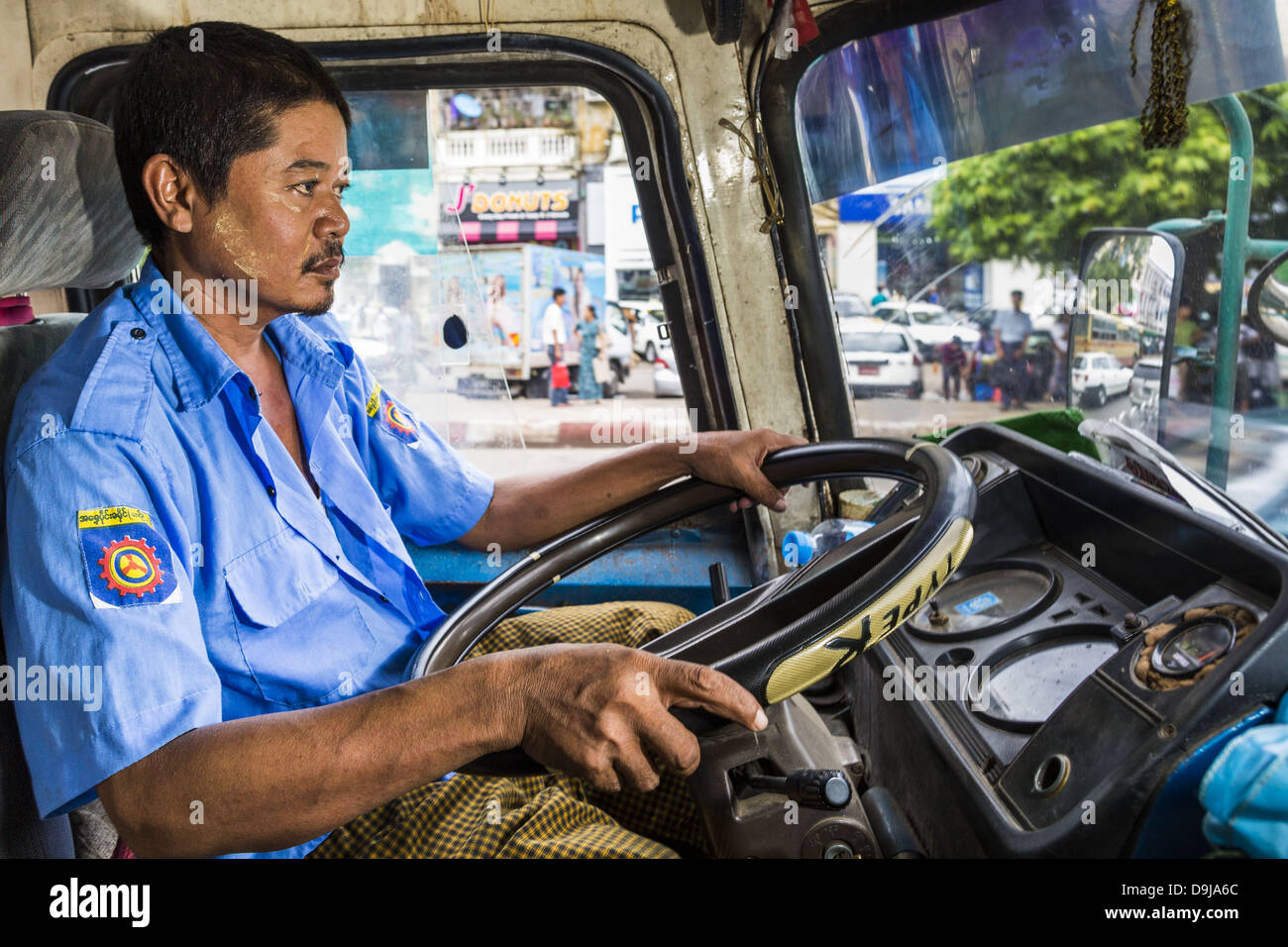 19. Juni 2013 - Rangun, navigiert Burma/Myanmar - Yangon A Busfahrer Stadtverkehr. Yangon-Busse sind in der Regel überfüllt und in den Armen zu reparieren, aber wie die Wirtschaft aber immer noch verwendet verbessert neuere, japanischen und koreanischen Busse importiert wird. Hunderte von Bus Routen Kreuz und quer durch Yangon, bietet die billigste Art der Fortbewegung in der Stadt. Die meisten Tarife sind weniger als den Gegenwert von .20Â ¢ US. (Bild Kredit: Jack Kurtz/ZUMAPRESS.com ©) Stockfoto