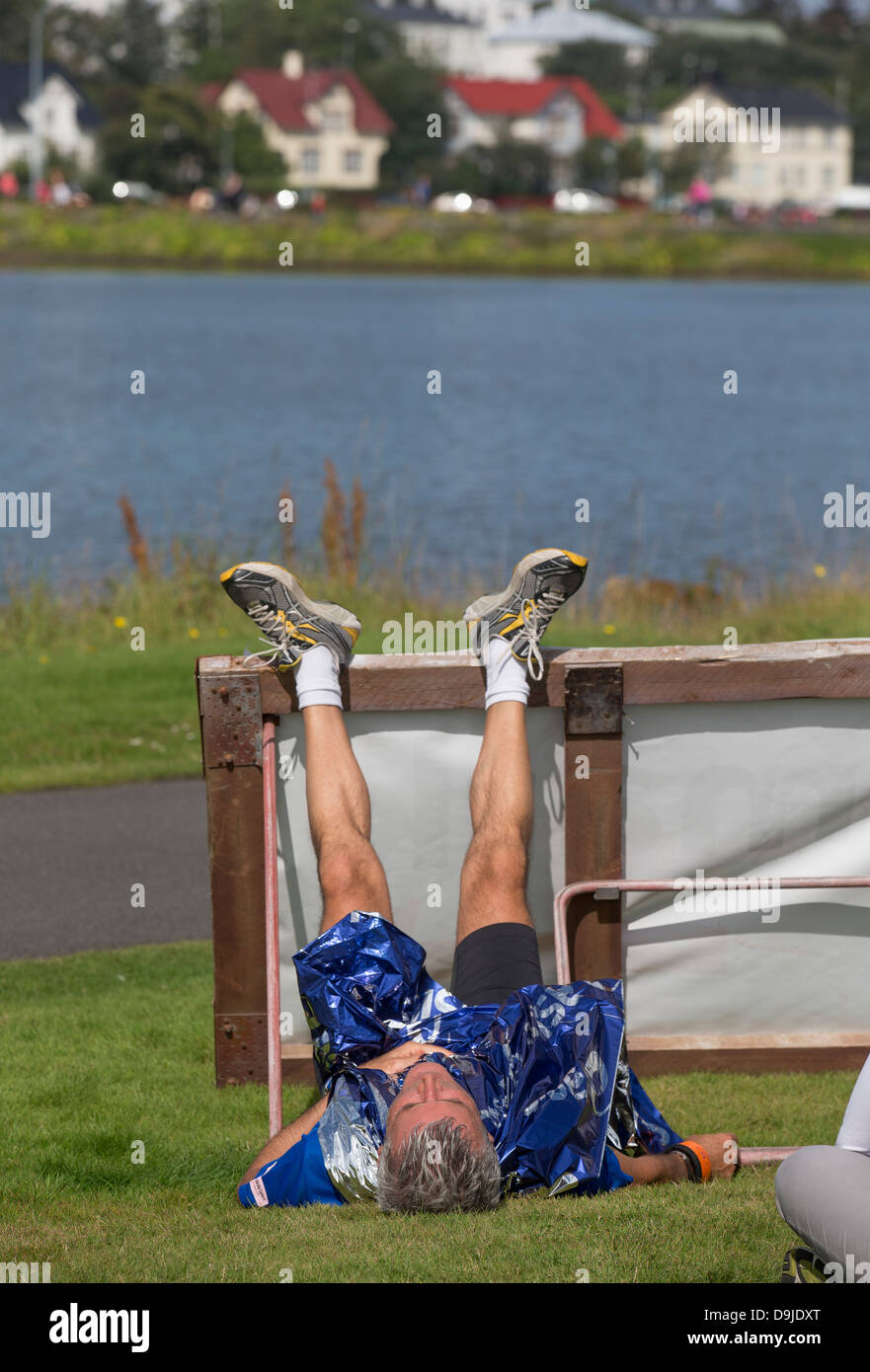 Läufer in eine Folie Decke gehüllt und ruhen Sie sich nach Reykjavik Marathon, Reykjavik, Island Stockfoto